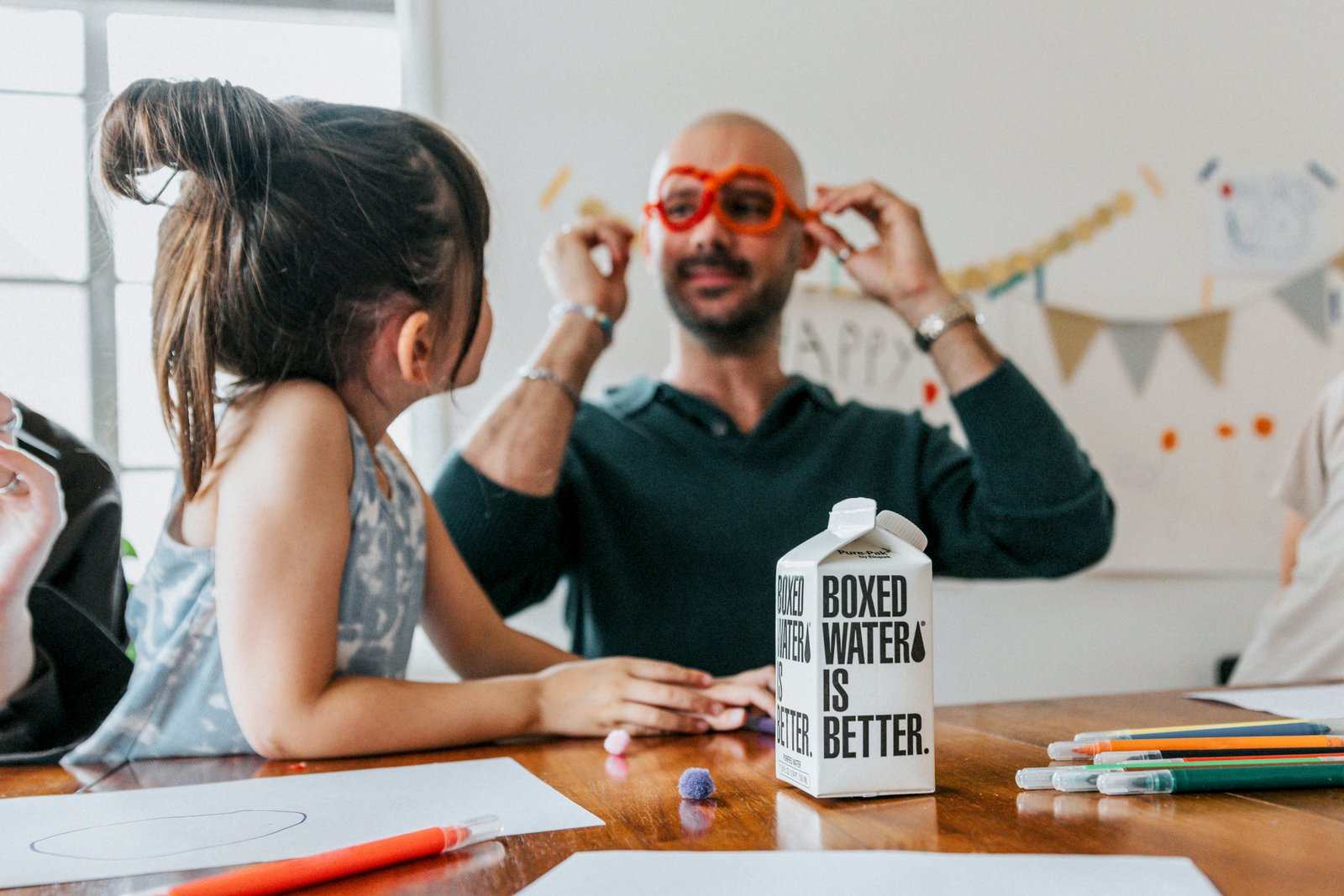 a man and a little girl sitting at a table with a milk carton